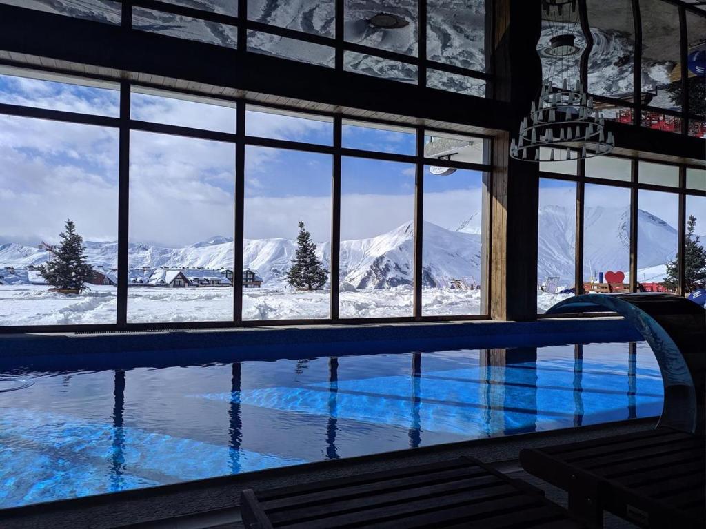 a swimming pool with a view of snow covered mountains at NEW GUDAURI ATRIUM 336 in Gudauri