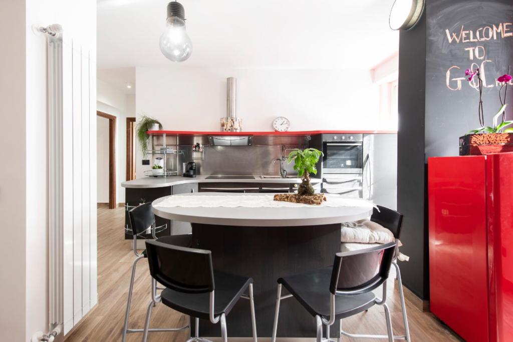 a kitchen with a white table and black chairs at G&C house in Rome