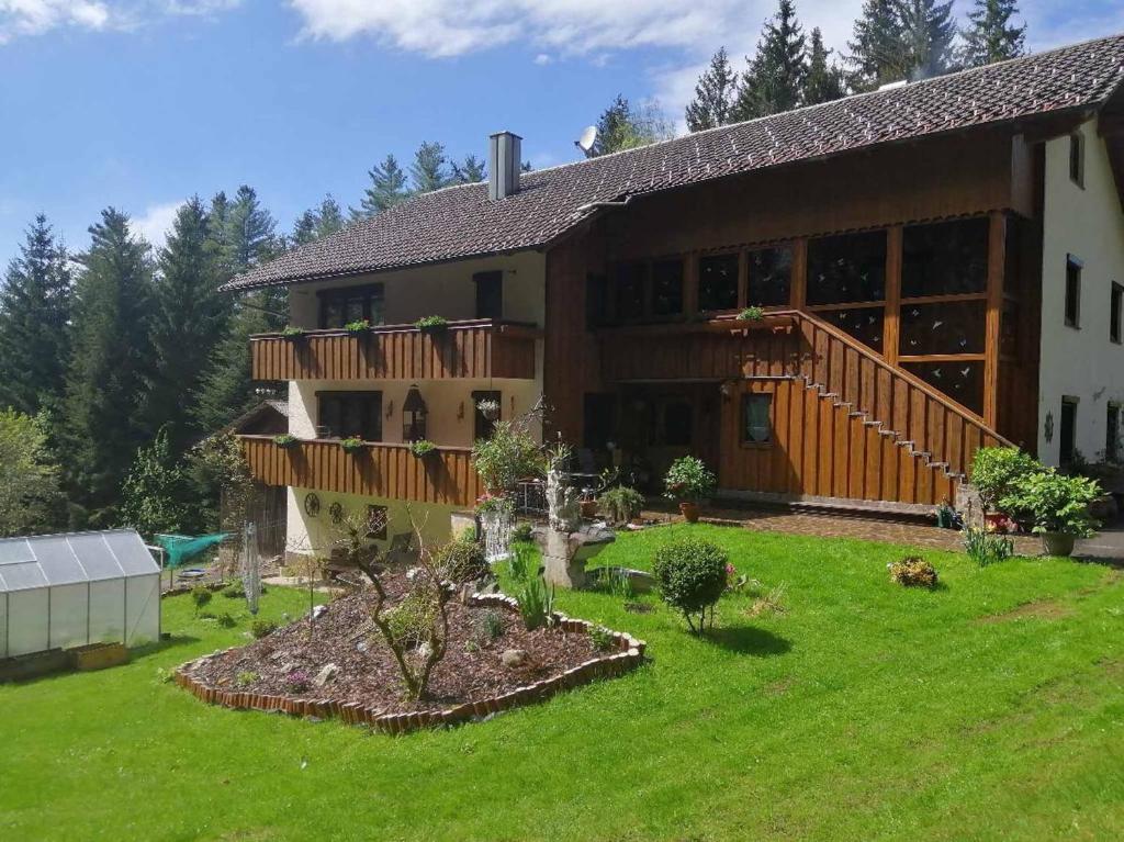 Una casa grande con un jardín enfrente. en Ferienwohnungen Berger, en Lam