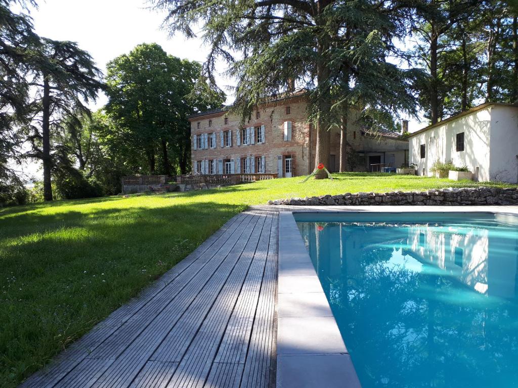 une maison avec une piscine en face d'une cour dans l'établissement Le Jardin Des Cèdres, à Lavaur