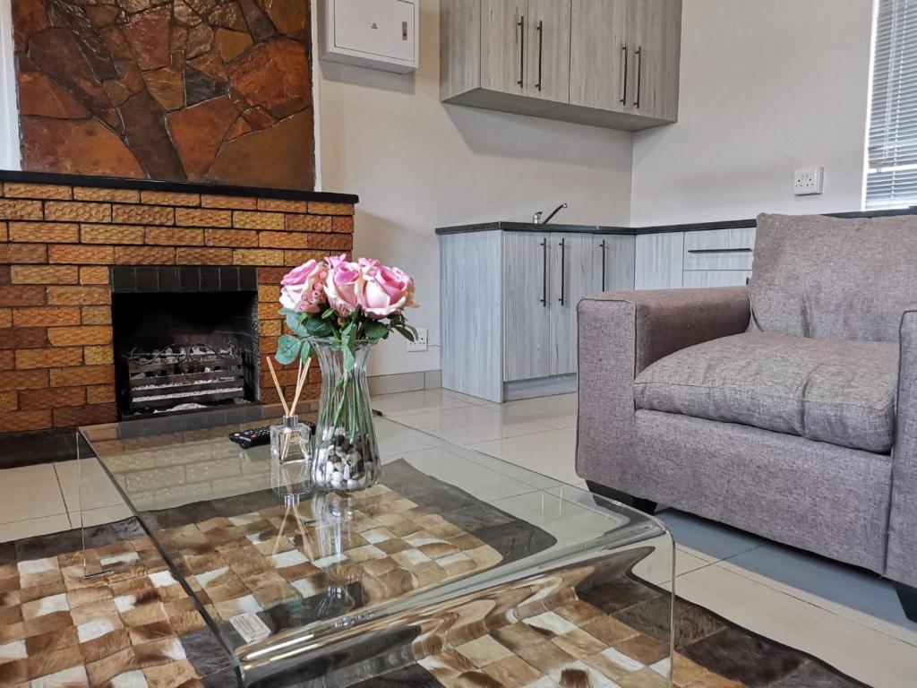 a living room with a fireplace and a vase of flowers on a table at @Anderson Executive Suites in Kimberley