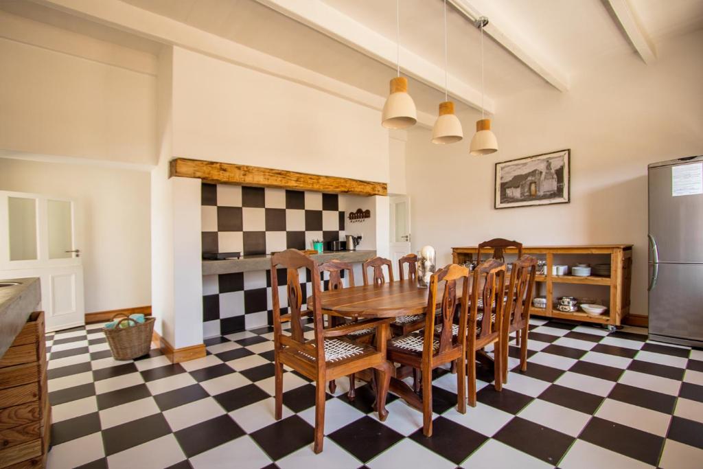 una cocina con mesa y sillas en un suelo a cuadros en Avondrust Guest House, en Klaarstroom