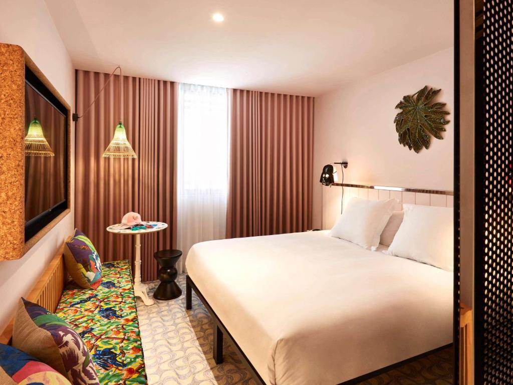 een hotelkamer met een groot bed en een stoel bij Mama Shelter Lisboa in Lissabon