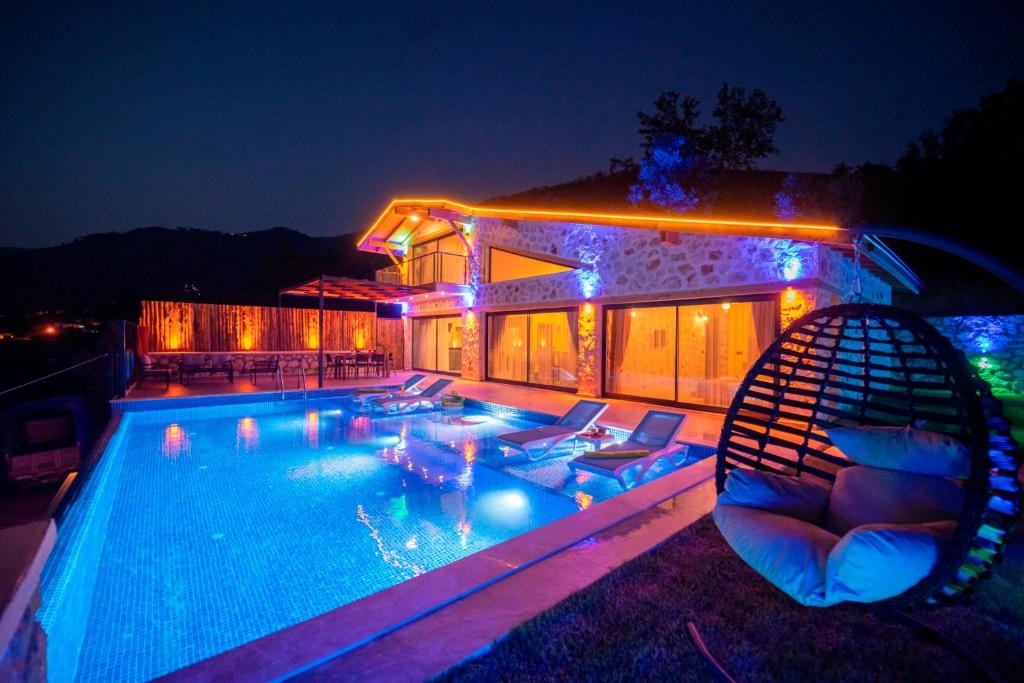 a house with a swimming pool at night at Elsu - 2 Bedroom Holiday Villa with jacuzzi in Kalkan in Çayköy