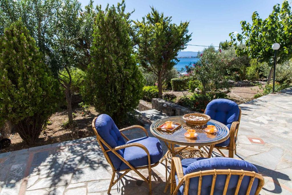 a patio with a table and chairs and the ocean at Villa Euphoria Studio in Aegina, A' Marathonas Bay in Egina