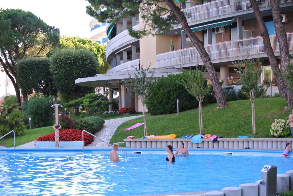 een groep mensen in een zwembad in een hotel bij DUNA 4 in Lignano Sabbiadoro