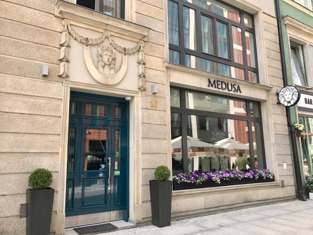 uma loja com um relógio na lateral de um edifício em Medusa Gdańsk Old Town em Gdańsk