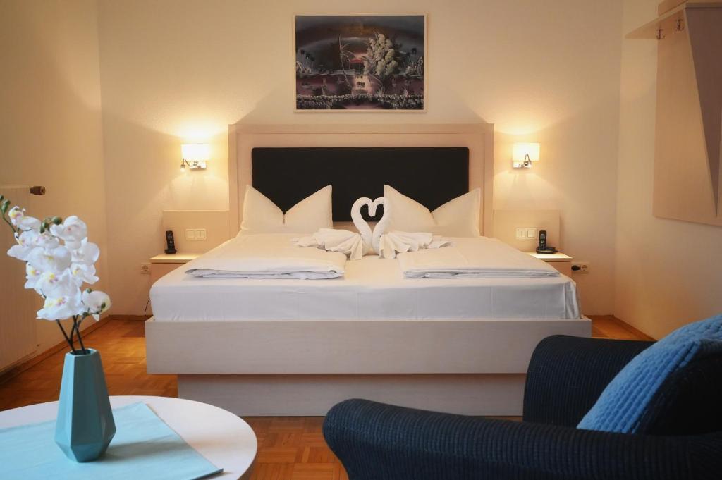 a bedroom with a bed with two swans on it at Hotel Scirocco in Baunatal