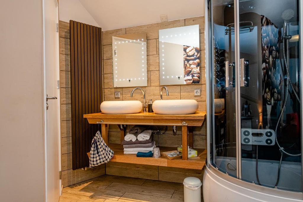 uma casa de banho com dois lavatórios e dois espelhos em B & B M 3 em Merkelbeek