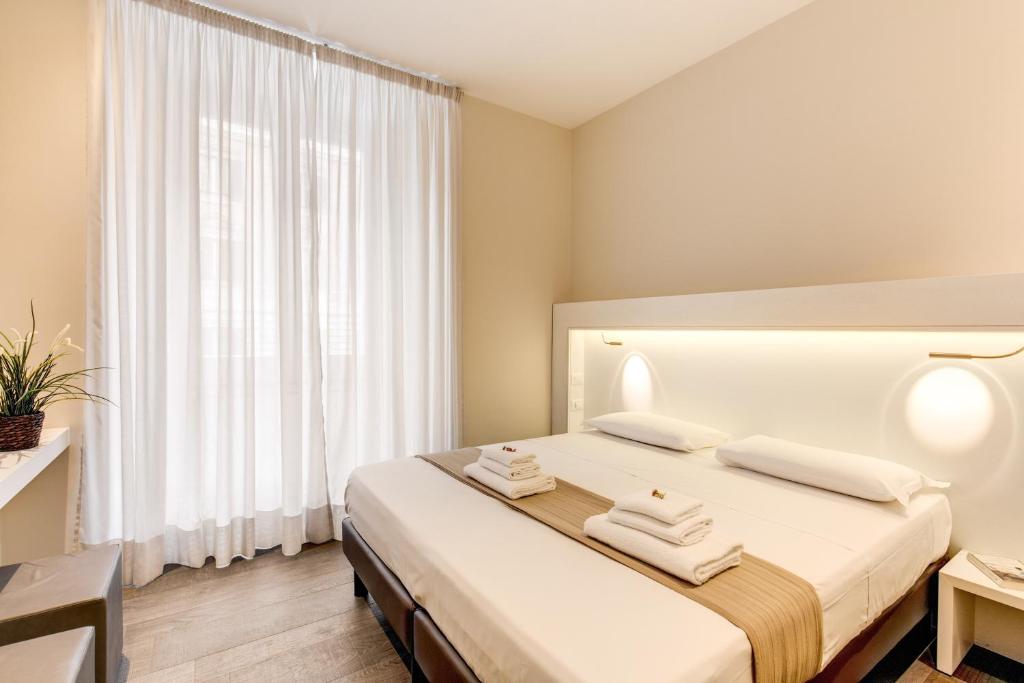 a bedroom with a large bed with towels on it at ECCE ROMA in Rome
