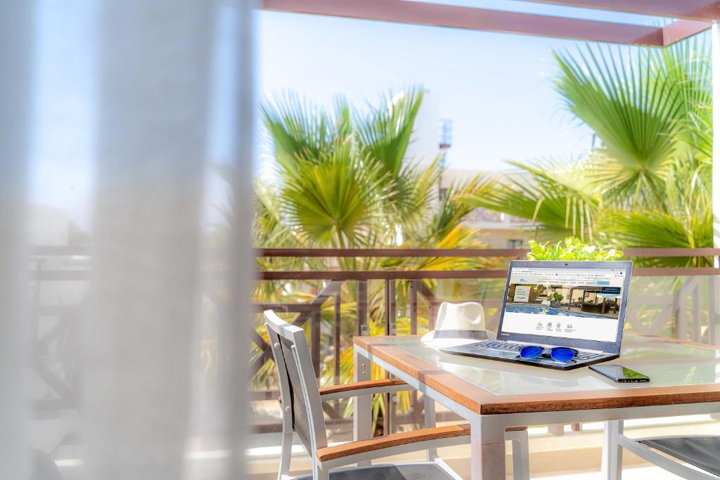 un ordenador portátil sentado en una mesa en un balcón en Natura Volcán By Vitalclass Lanzarote Resort, en Costa Teguise