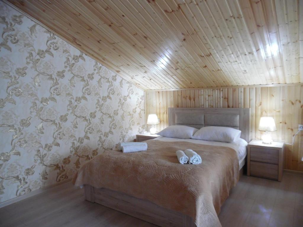 a bedroom with a bed with two shoes on it at Guest House Tamta in Stepantsminda