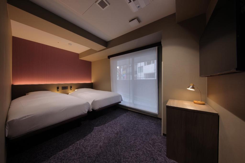 Postel nebo postele na pokoji v ubytování Hotel SUI Kobe Sannomiya by ABEST