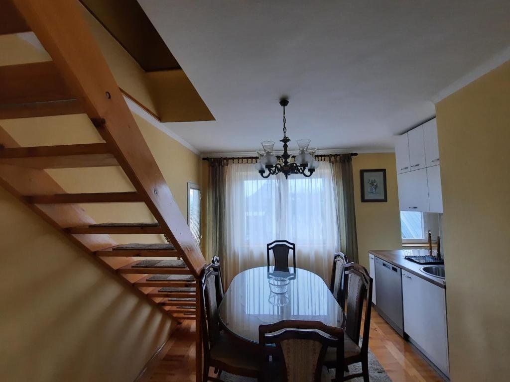 a dining room with a table and a kitchen at Apartman Glomazic in Žabljak