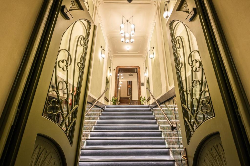 a staircase leading to a building with a chandelier at Liebeskind Boutique Hotel Old Town in Kraków