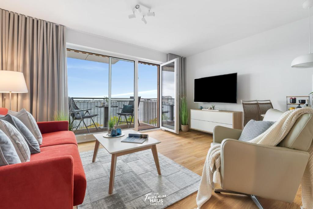 a living room with a red couch and a tv at Jolle in Olpenitz