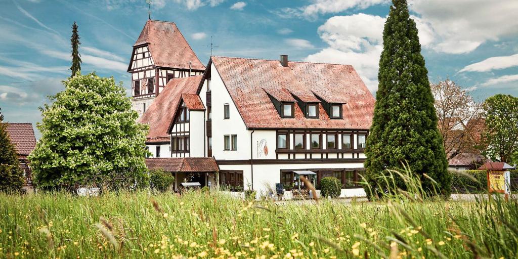 ein großes weißes Haus mit rotem Dach in der Unterkunft Landgasthof Sonne in Mainhardt