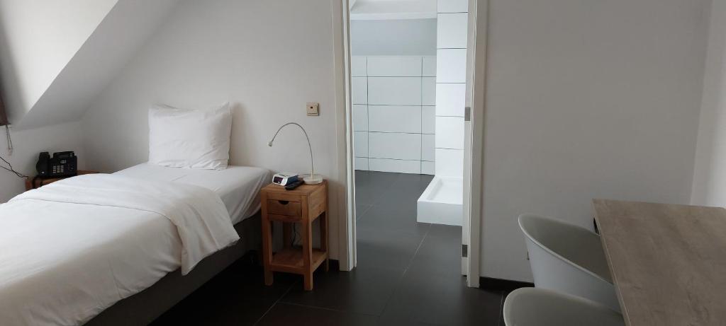 a bedroom with a bed and a bathroom with a sink at Lavan in Leuven