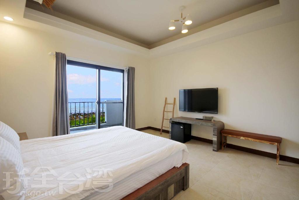 1 dormitorio con 1 cama y TV de pantalla plana en OceanSeeker en Green Island