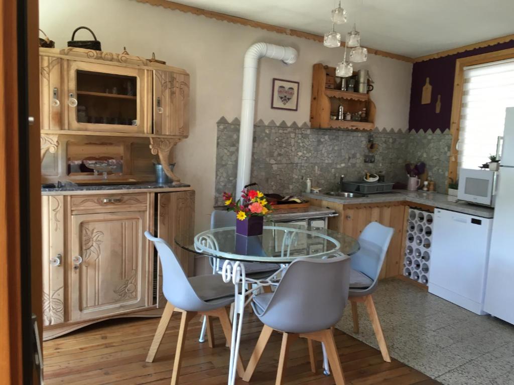 een keuken met een glazen tafel en stoelen bij Maison de campagne dans le village in Saint-Pierre