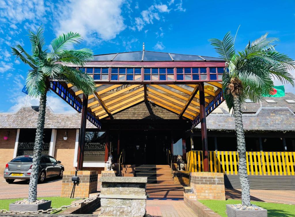 un edificio con dos palmeras delante en The Lovat Hotel, en Perth