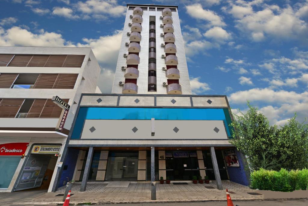 a tall building with a sign in front of it at Vind's Plaza Hotel in Caratinga