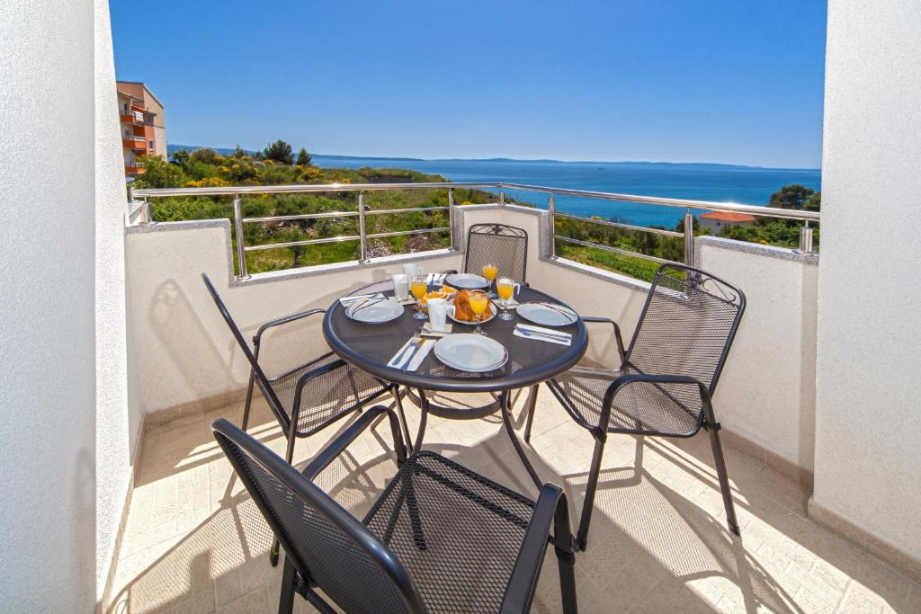 stół i krzesła na balkonie z widokiem na ocean w obiekcie The View Apartments w Splicie