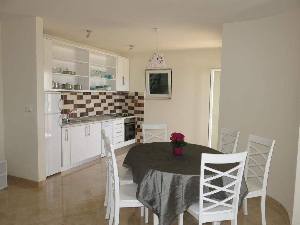 cocina y comedor con mesa y sillas en Sunset Apartment, en Trogir