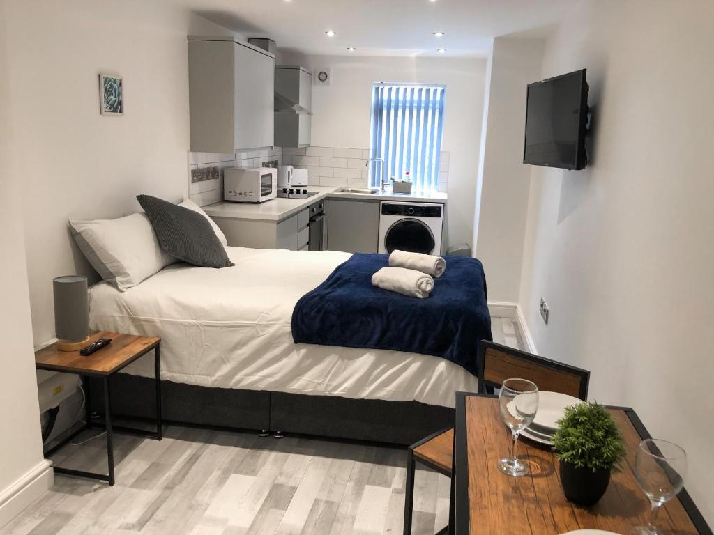 a small bedroom with a bed and a kitchen at 10min to City - FREE Parking - Private Studio - Contractor Friendly in Manchester