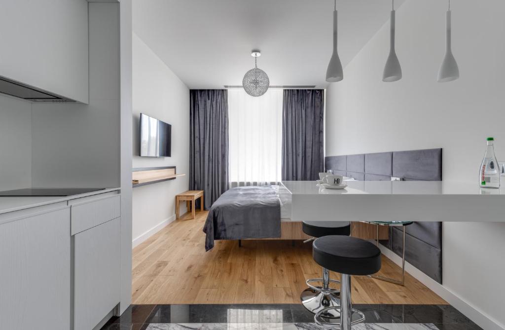 a kitchen and living room with white cabinets and a table at BASIS APARTMENTS - Adults Only in Kyiv