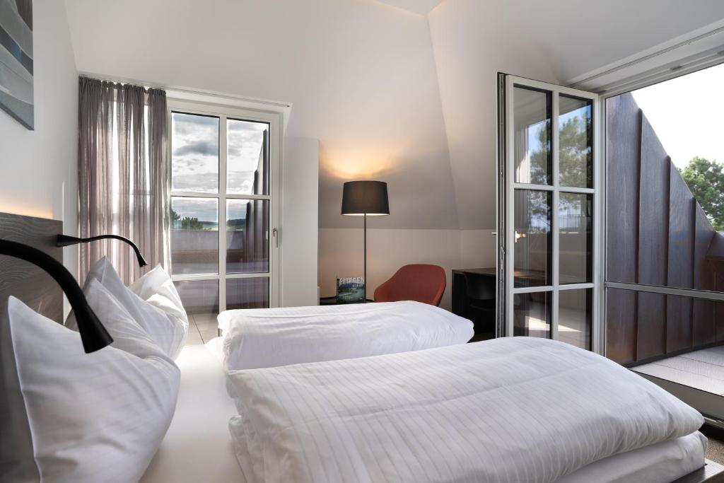 a hotel room with two beds and a window at Hotel Spitzerberg by b-smart in Hundsheim