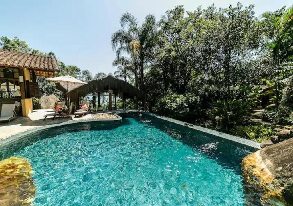 una piscina frente a una casa en Refúgio Guest House, en Ilhabela