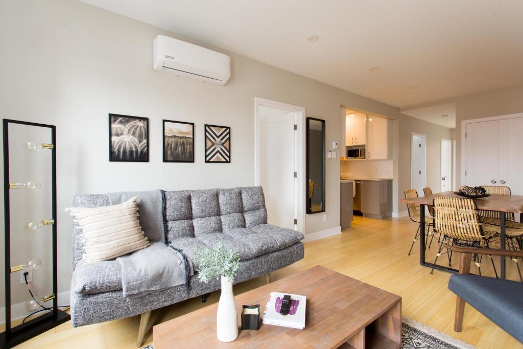 a living room with a couch and a table at Trendy Little Italy 3 Bedroom Condo by Den Stays in Montréal