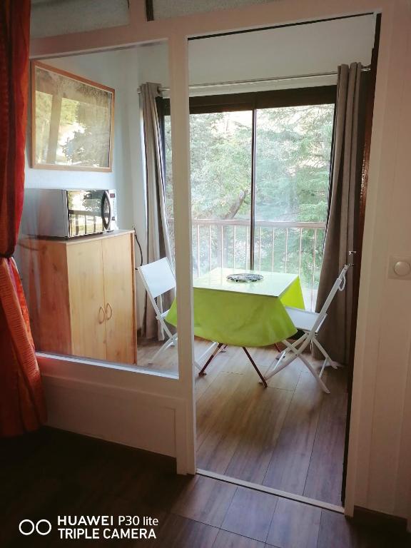 a view of a room with a table and a balcony at Superbe studio avec ascenseur à 50 mètres des cures et du centre ville in Vernet-les-Bains