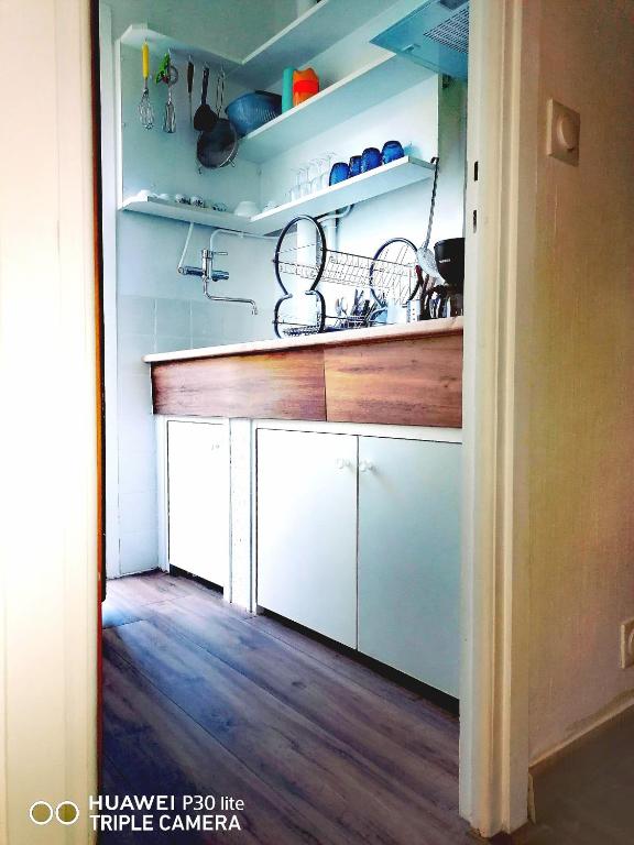 a kitchen with white cabinets and a wooden counter top at Superbe studio avec ascenseur à 50 mètres des cures et du centre ville in Vernet-les-Bains