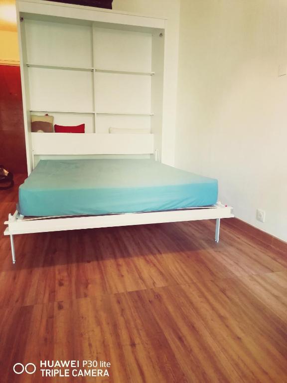 a bed in a room with a wooden floor at Superbe studio avec ascenseur à 50 mètres des cures et du centre ville in Vernet-les-Bains