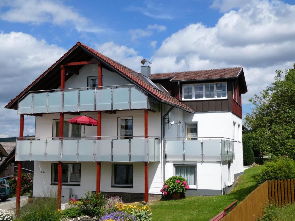 een wit huis met een bruin dak bij Ferienwohnungen Schallerhof in Bischofsgrün