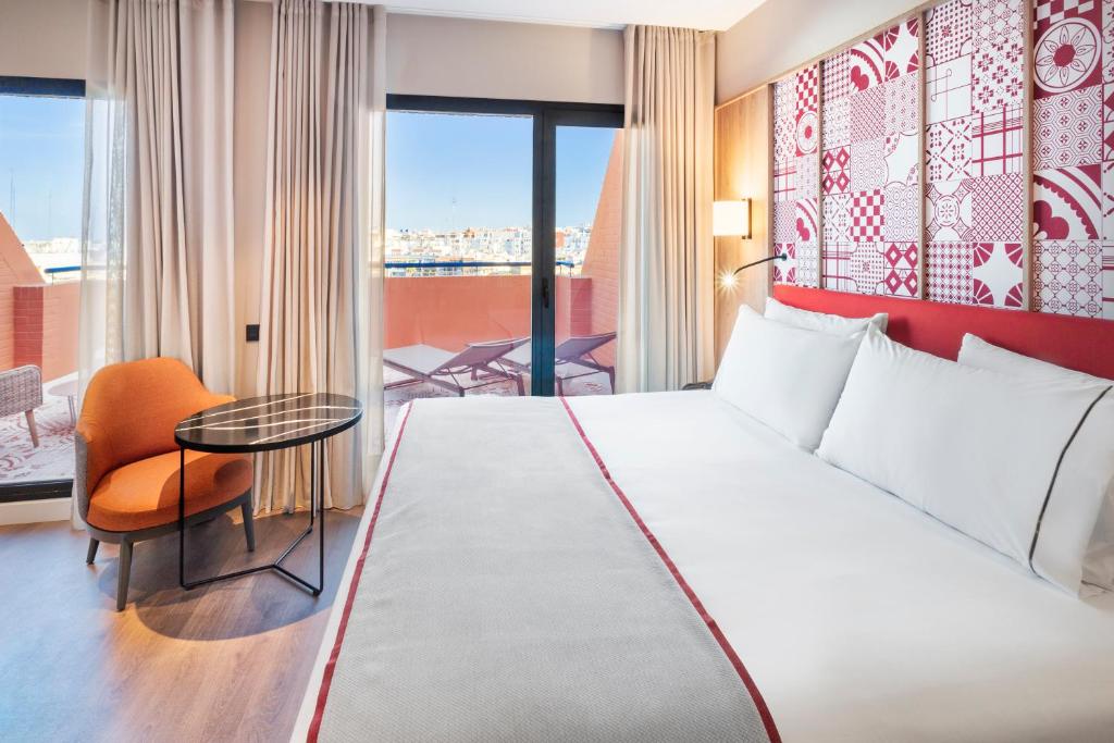 una habitación de hotel con una cama grande y una mesa en Eurostars Guadalquivir, en Sevilla