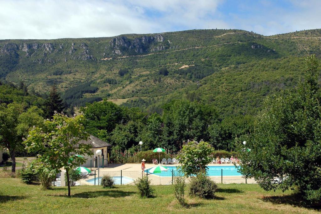 une piscine avec une montagne en arrière-plan dans l'établissement VVF Les Cévennes, à Florac Trois Riviere