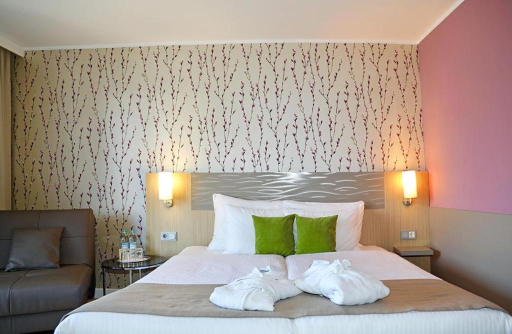 een slaapkamer met een bed met twee handdoeken erop bij Hotel New Orly in München