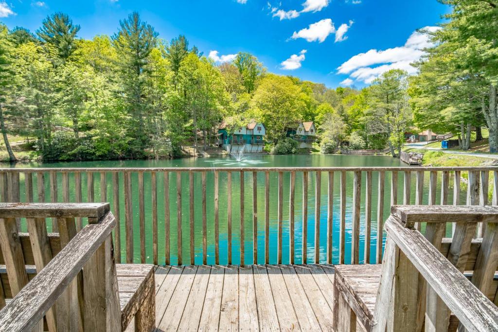 a wooden bridge over a lake with trees at Swiss Mountain Village in Blowing Rock