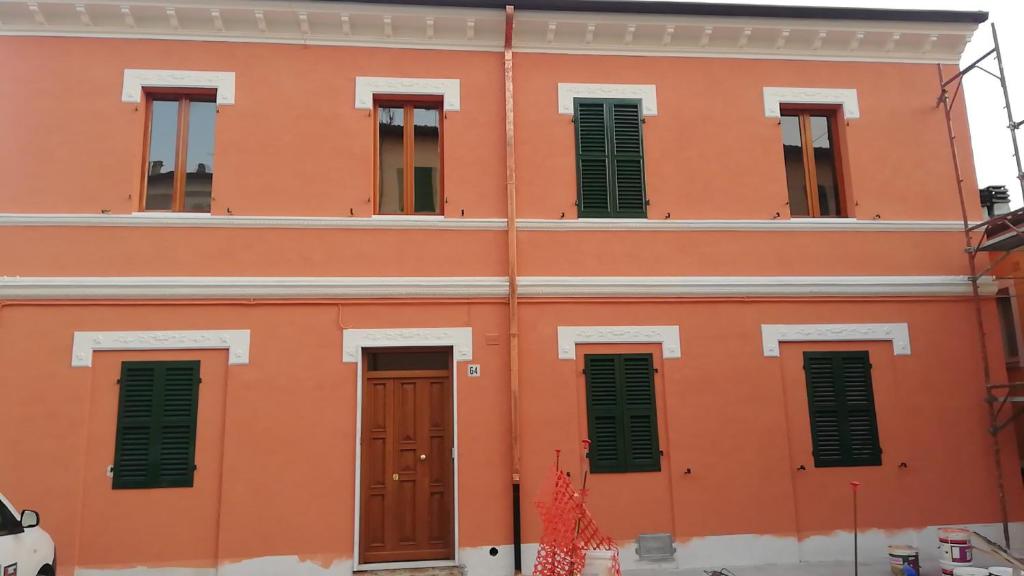 モンテマルチャーノにあるLa Casa di GiuSyの緑の襖と扉のあるオレンジ色の建物