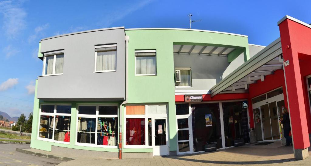 a building that is painted green and white at Rooms Funda Lepoglava in Ivanec