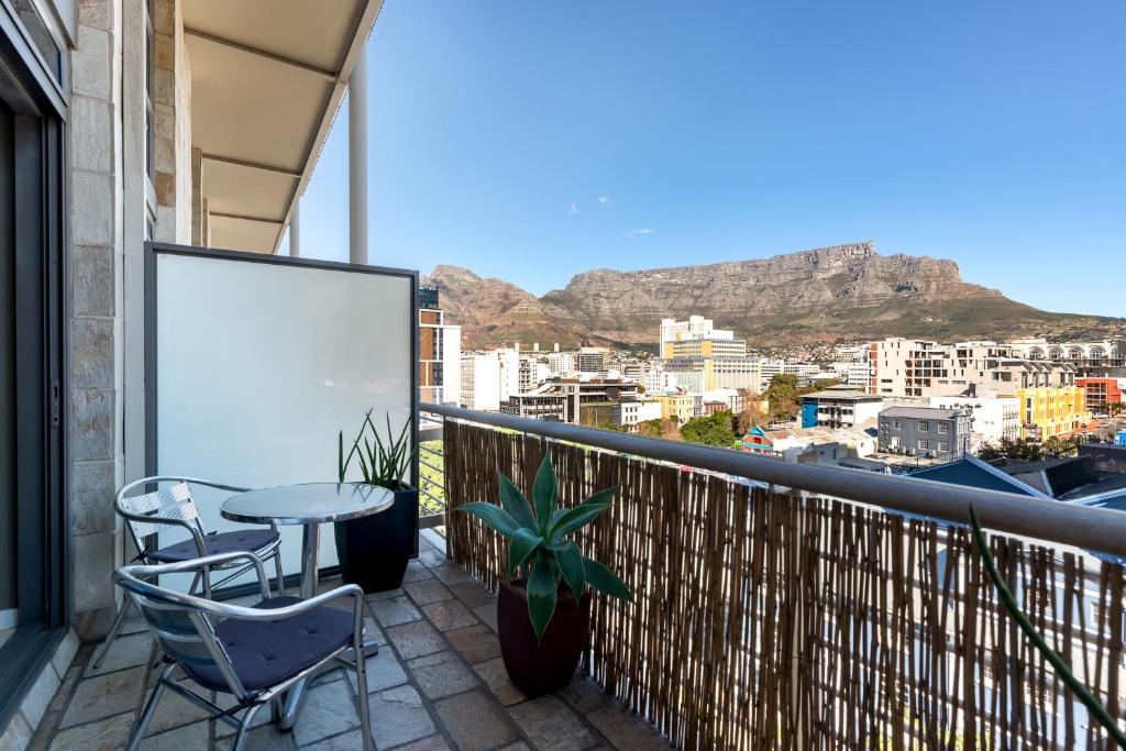 a balcony with a table and chairs with a view at City Slicker Double Volume Loft, Magnificent Table Mountain View, close to V&A Waterfront, never any load shedding! in Cape Town