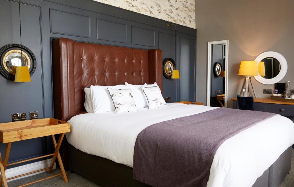 a bedroom with a large bed with a brown headboard at Riverside Inn by Chef & Brewer Collection in Shrewsbury