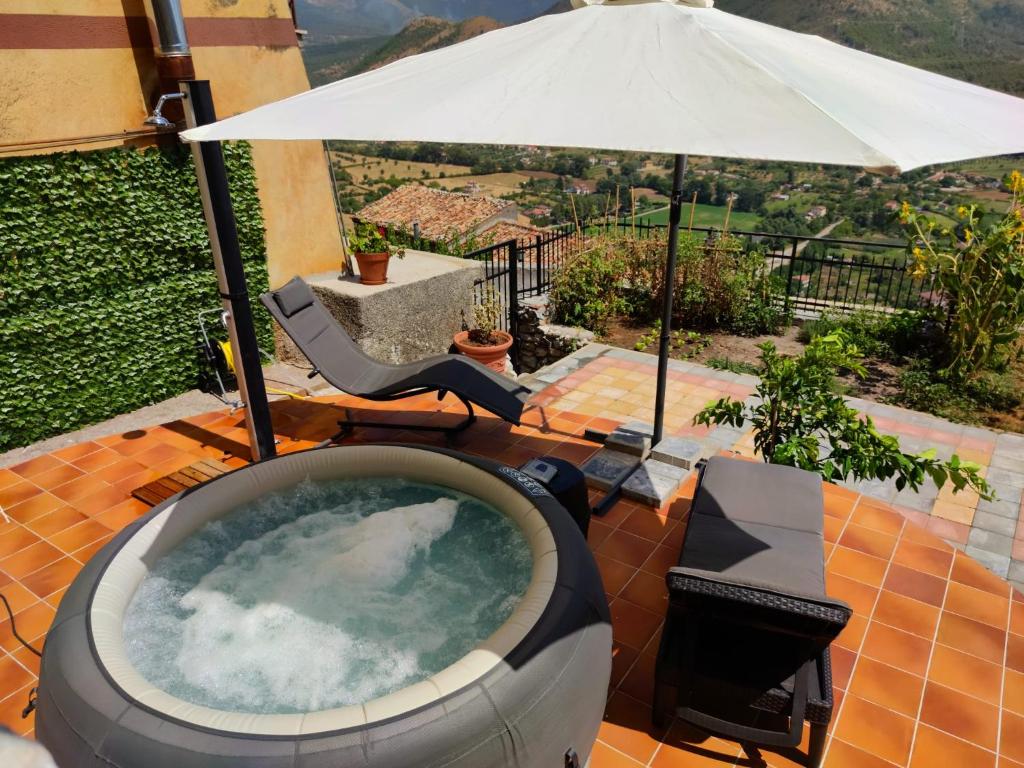 a hot tub on a patio with an umbrella at Al Castello in Morano Calabro