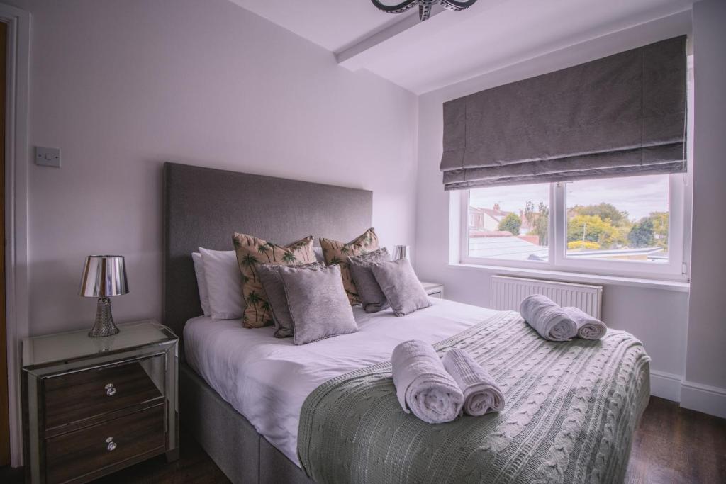 a bedroom with a large bed with towels on it at Haven House Rooms, Barry in Barry