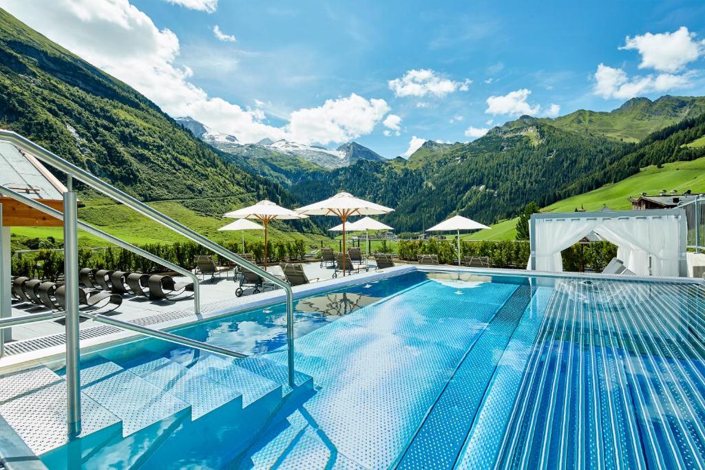 a swimming pool with a balcony overlooking the ocean at Hotel Berghof Crystal Spa & Sports in Tux