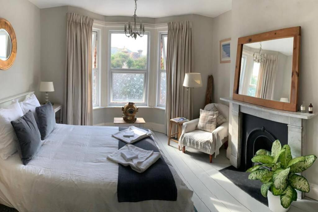 a bedroom with a large bed and a fireplace at Sea Proche in Sandown