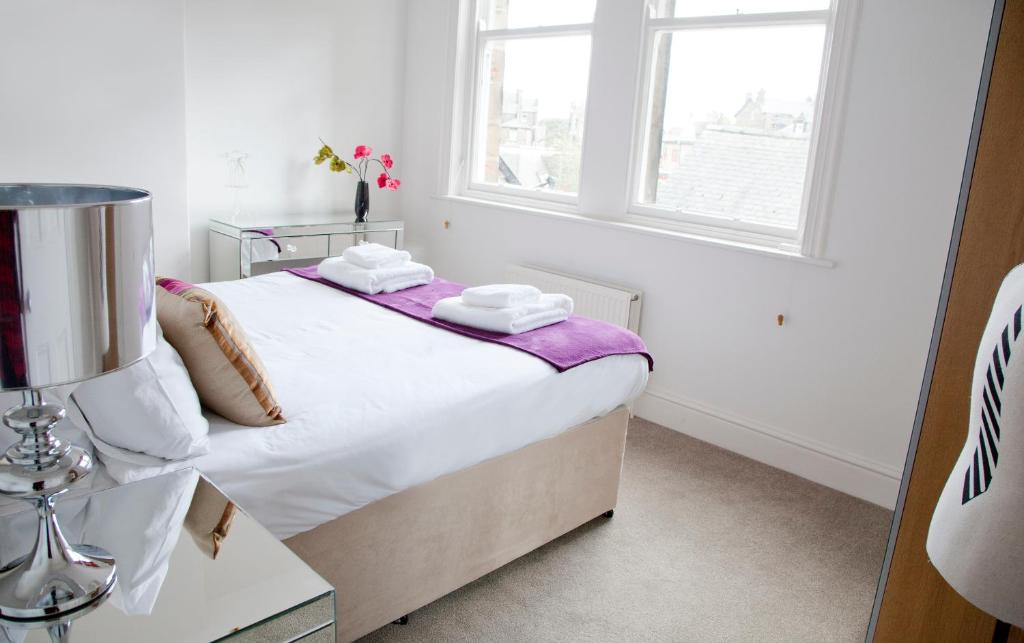 a small white bedroom with a bed and a window at Valley View in Harrogate